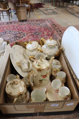 a box full of tea cups and saucers sitting on the floor