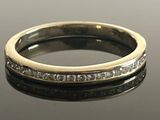 a close up of a diamond ring on a reflective surface