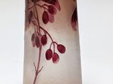 a glass vase with a flower on it on a white surface
