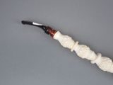 a pipe with a carved handle on a gray surface