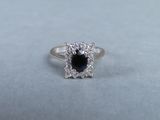 a close up of a ring with a black stone surrounded by white diamonds