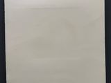 une feuille de papier blanche accrochée à un mur noir