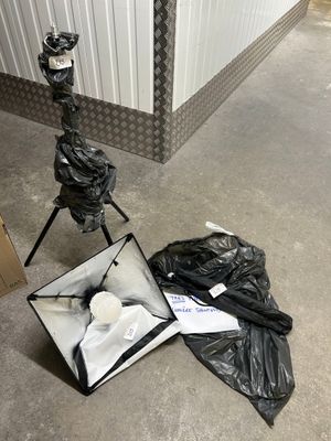 a bag of trash on the ground next to a tripod