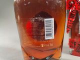 a bottle of liquor sitting next to a box of candy
