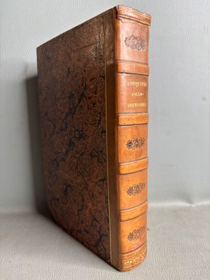 an old book with a brown cover sitting on top of a table
