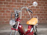 a red motorcycle parked in front of a brick wall