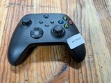 un gros plan d'une manette de jeu posée sur une table en bois