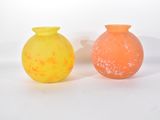 des vases jaunes et orange posés côte à côte sur une surface blanche