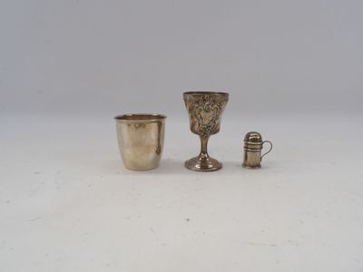 deux tasses en argent et une tasse en argent posées sur une surface blanche