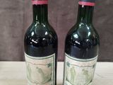 two bottles of wine sitting on top of a table next to each other