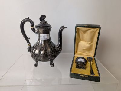 a silver tea pot sitting on a table next to an open box