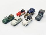 several toy cars are lined up in a row on a white surface