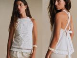 a woman that is wearing a white top and shorts