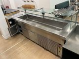 a stainless steel kitchen with a glass counter top