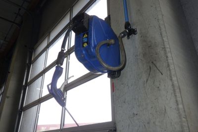 un tuyau bleu fixé au mur près d'une fenêtre