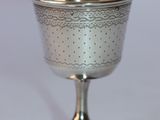 a silver cup sitting on top of a white table