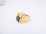 a close up of a gold ring with a black stone