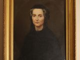 a painting of a woman in a black dress is hanging on a wall