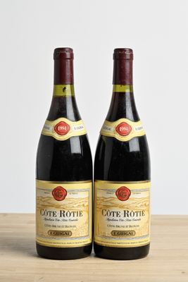 two bottles of wine sitting on top of a wooden table