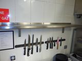 beaucoup de couteaux accrochés au mur de la cuisine