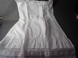 white dress on a hanger on a table next to a bottle of wine