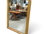 a mirror that is sitting on the floor in front of a table