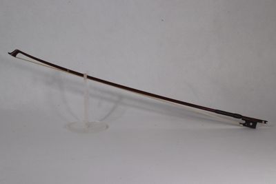 une image représentant un arc posé sur un support, sur une surface blanche