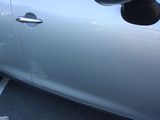 a silver car parked in a parking lot with its door open