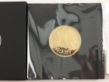 une médaille d'or dans une boîte noire posée sur une table blanche