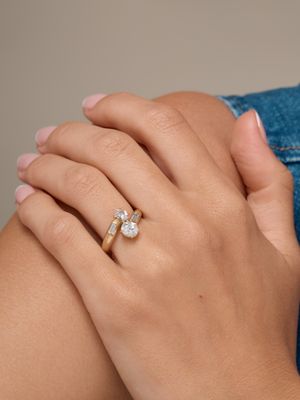 Cette femme porte une bague en or sertie d'un diamant.