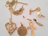 plusieurs types différents de bijoux en or posés sur un fond blanc