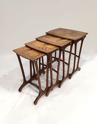 un ensemble de trois tables gigognes en bois sur fond blanc