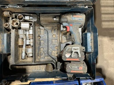 une boîte à outils contenant des outils, posée sur le sol