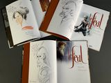 three books with drawings of a woman and a man sitting on a table
