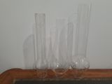 trois vases transparents posés sur une table recouverte d'un napperon noir