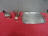 un plateau en argent posé sur une table rouge, avec une théière en argent et une théière en argent