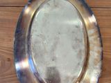 a silver plate on a wooden table with a mirror on it