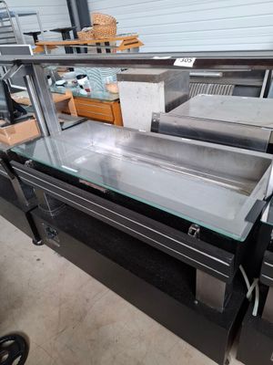 une table en verre avec un plateau en verre dans un entrepôt