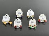 six pairs of earrings with price tags on them sitting on a table