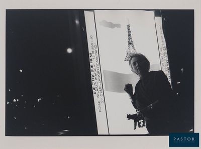 photographie en noir et blanc d'un homme tenant un appareil photo devant une fenêtre