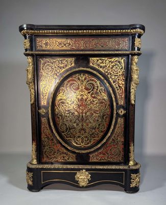 une image représentant une armoire peinte en noir et or, surmontée d'une horloge