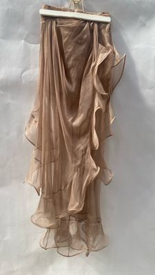 the skirt is hanging on a hanger on a white wall