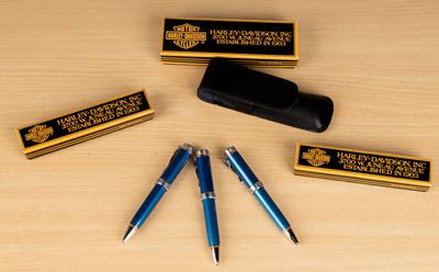 three pens and a pen case sitting on a table
