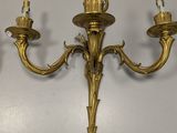 pair of antique brass wall sconces on a white wall
