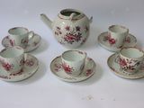 cinq tasses et soucoupes ainsi qu'une théière sur la table