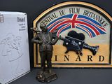a statue of a man holding a gun next to a sign