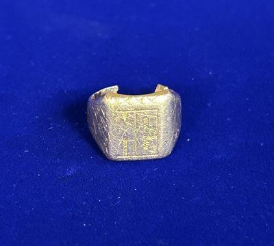 un gros plan d'une bague en or sur une surface bleue