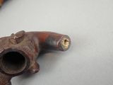 a pipe that is sitting on a table next to a piece of wood