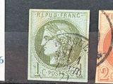 three different colored stamps on a black surface, one with a woman ' s head and one with a man ' s head