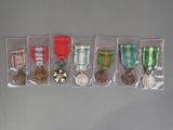 several medals and medals are displayed in plastic bags on a gray surface